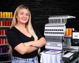 Woman standing in front of an embroidery machine swift 20 needles with colorful thread wall in the background